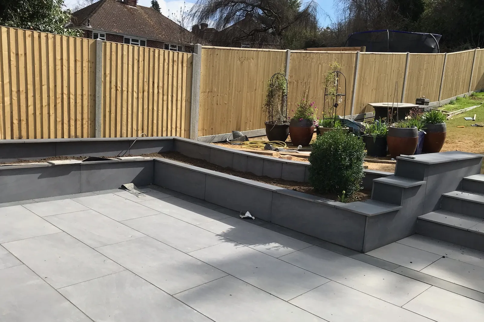 Raised block beds and steps round a porcelain patio, Tilehurst, Reading, 2022