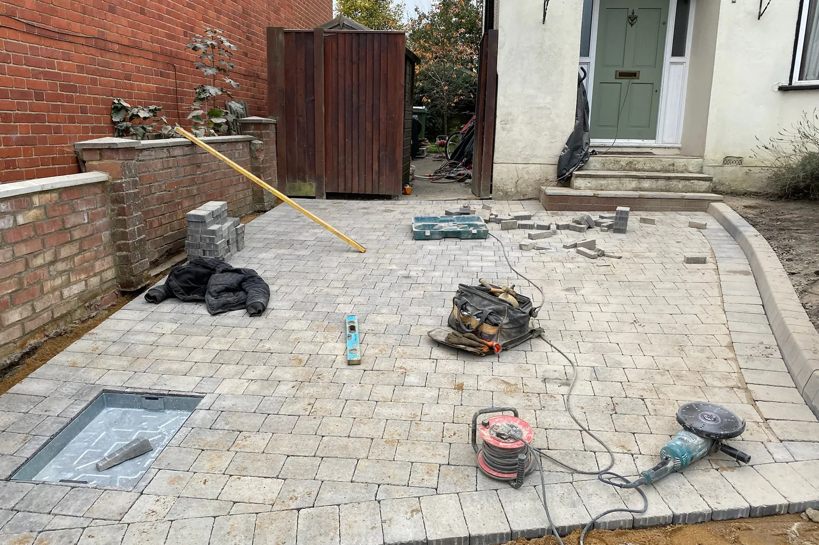 Paving laid up to the front steps, the edges being cut, Maidenhead, 2024