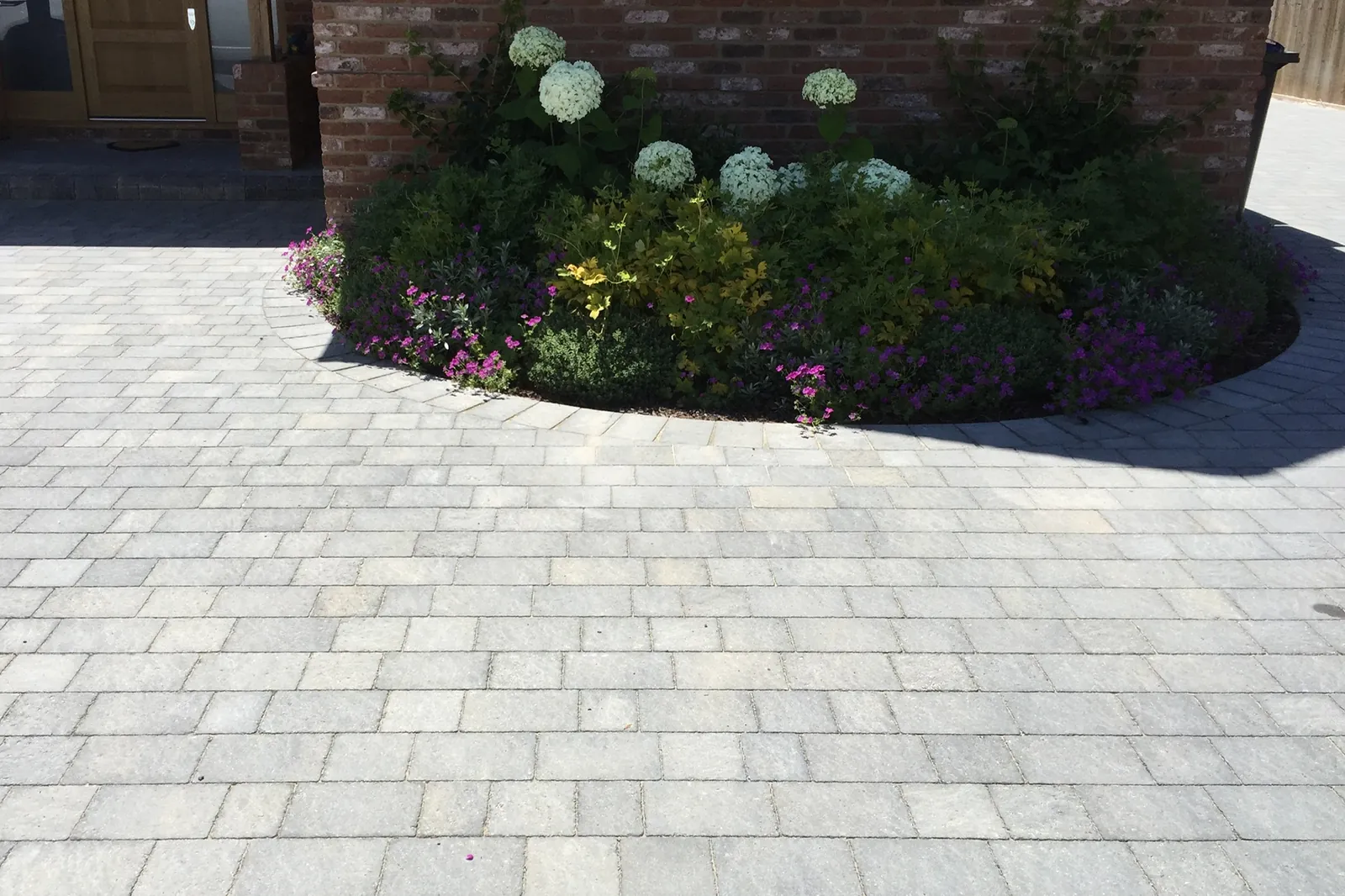 Grey setts drive curving round a planted bed, Virginia Water, 2017