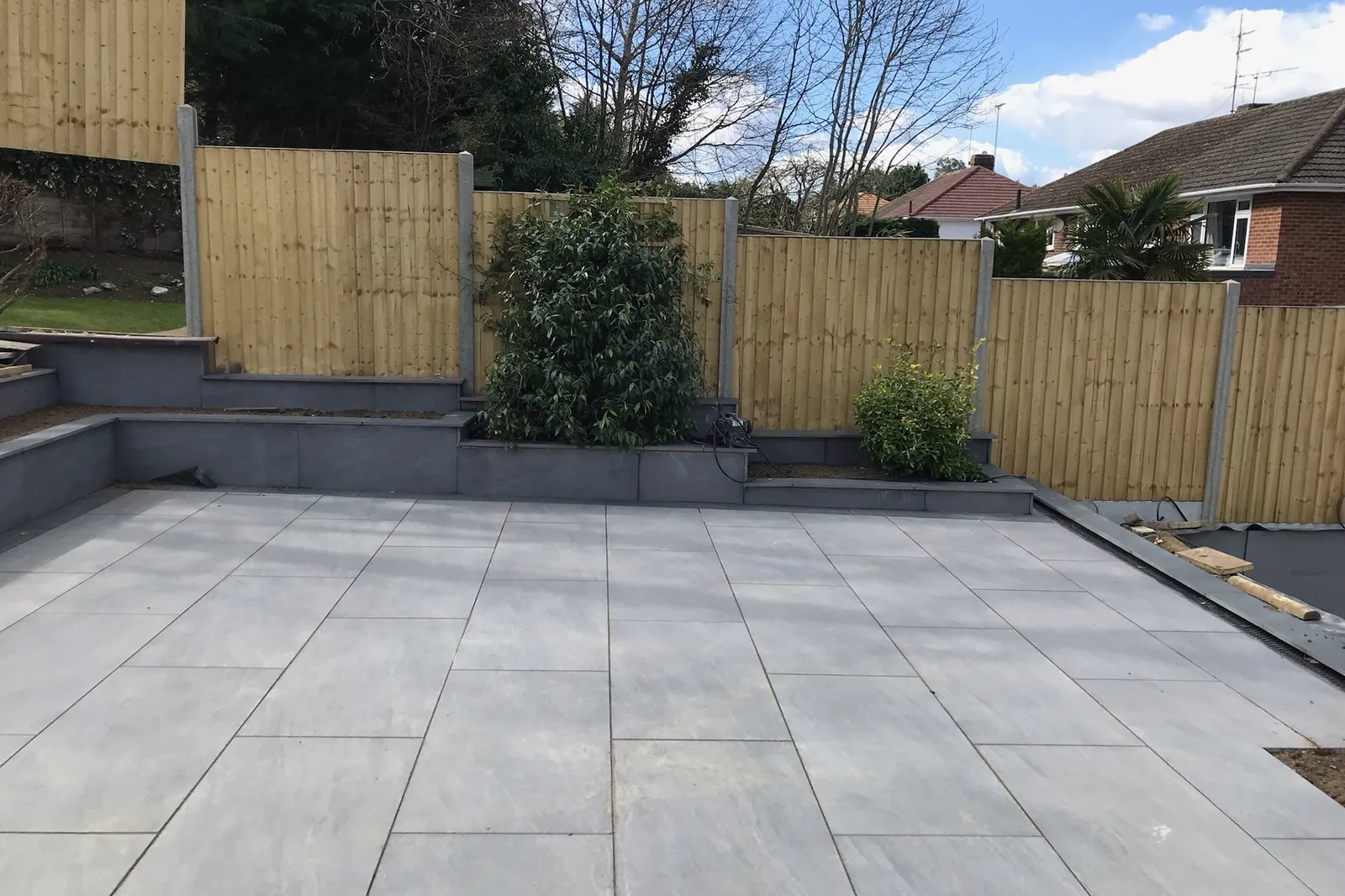 Feather-edge fencing on concrete posts above a porcelain patio, Tilehurst, Reading, 2022