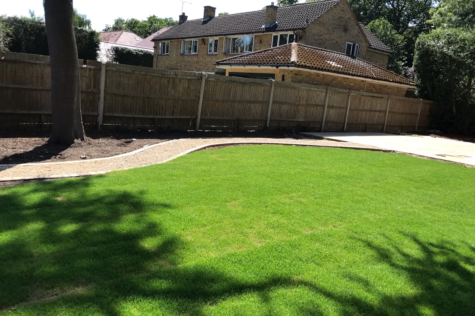 New lawn with a curved gravel path and setts edging, Farnham Royal, Slough, 2020