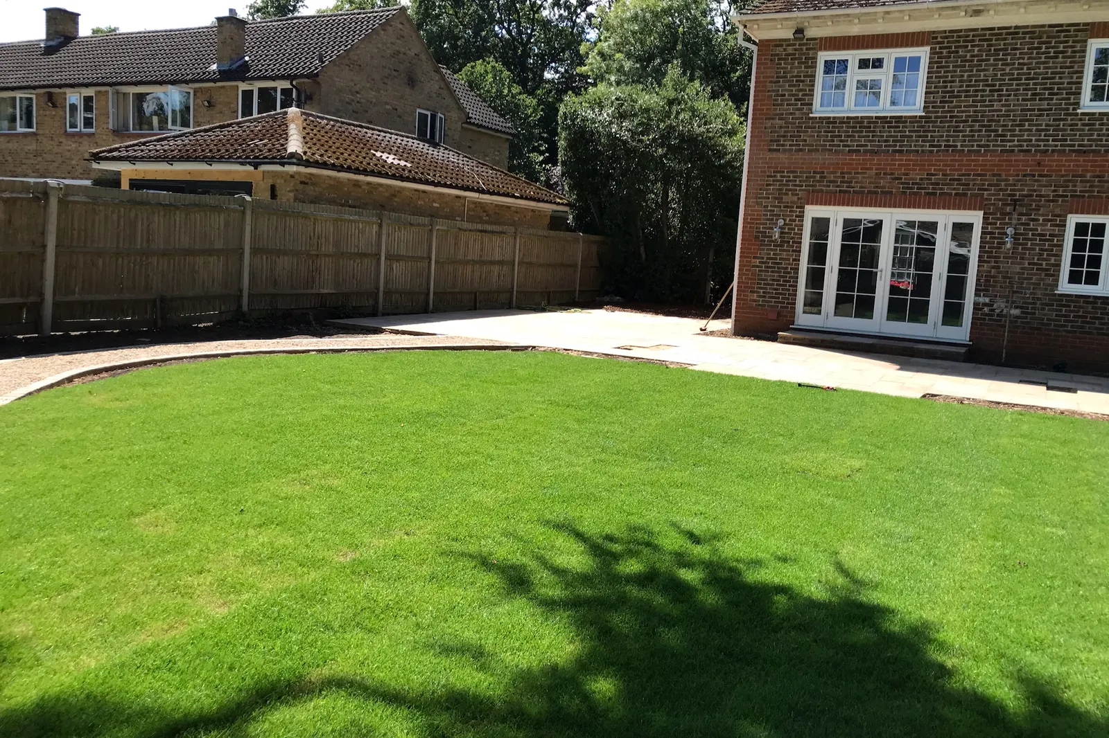 Sandstone patio along the back of the house, new lawn and fencing, Farnham Royal, Slough, 2020