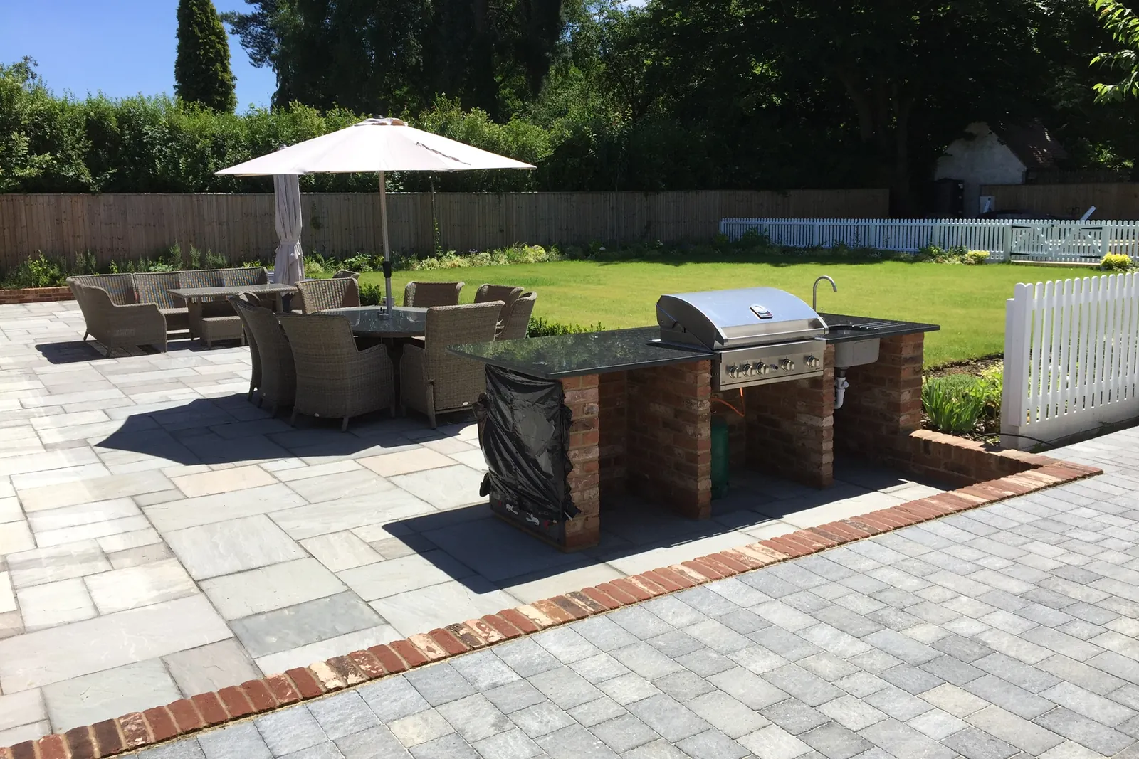 Sandstone patio with a brick-built barbecue and garden furniture, Virginia Water, 2017