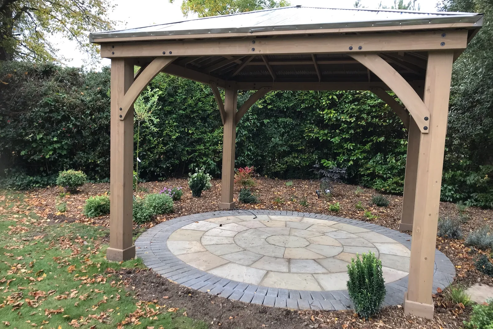 Roofed timber pergola on a circular sandstone patio, Farnham Royal, Slough, 2021
